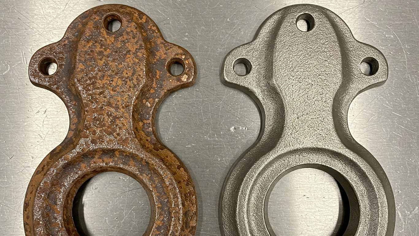 Iron surface undergoing laser cleaning showing precise contamination removal