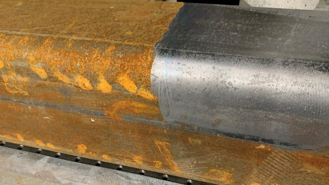 Pulsed 1064 nm head removing field rust from a Bay Area structural-steel flange